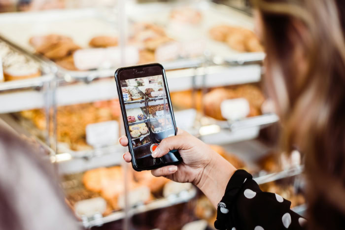 Woman taking phone video of a bakery display