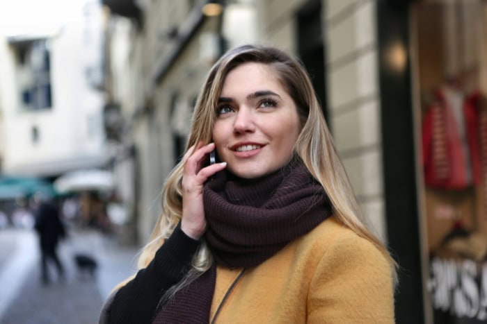 Woman talking on phone while walking in city street