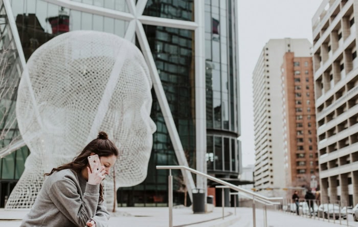 Woman talking on smartphone in urban setting with modern architecture