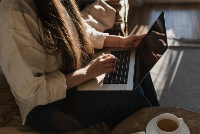 Woman typing on a laptop in natural light