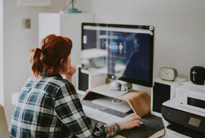 Woman using desktop computer in home office