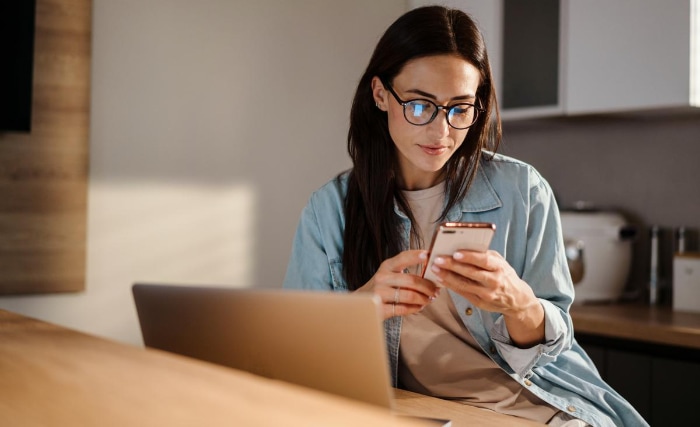 Woman using iphone while sitting