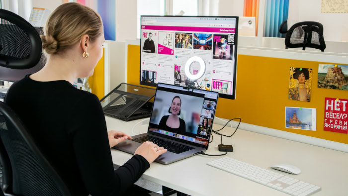 Woman using laptop and monitor for video conference