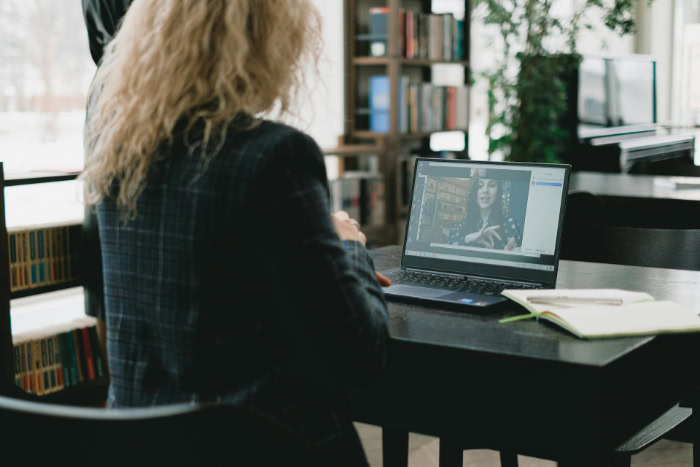 Woman using laptop for video call in library