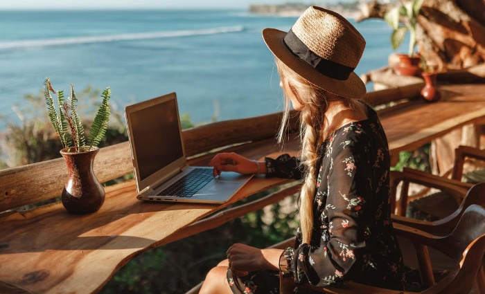 Woman using laptop on beachside cafe