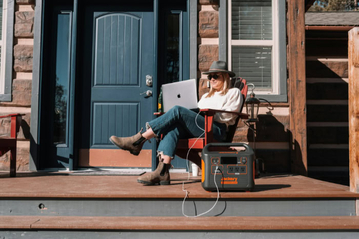 Woman using laptop with Jackery portable power station
