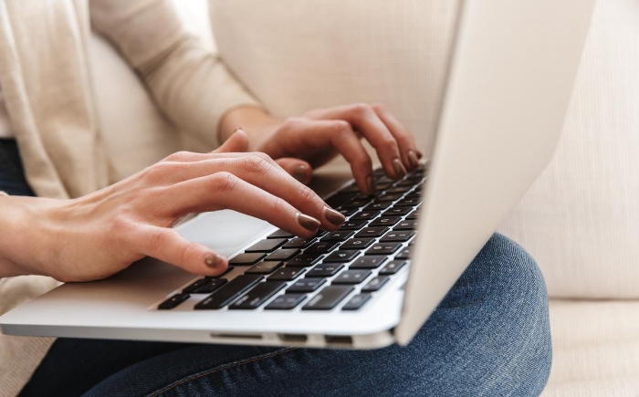 Woman using macbook on couch