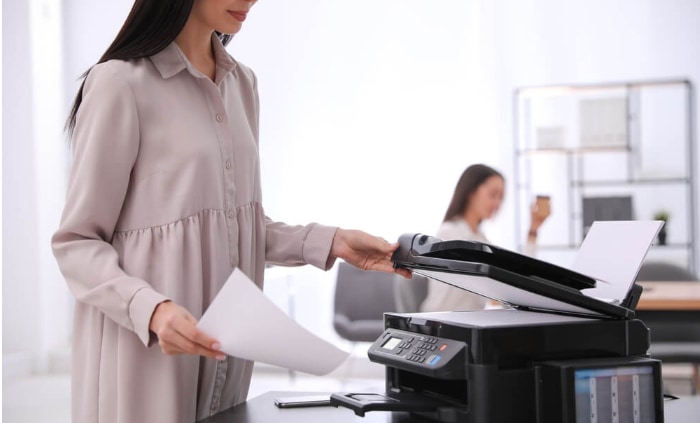 Woman using modern printer in office