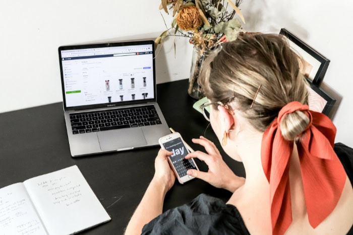 Woman using smartphone and laptop