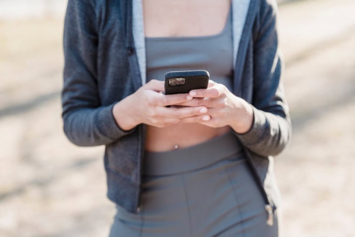 Woman using smartphone while wearing sweater