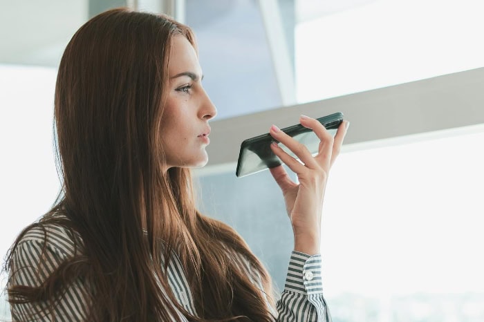 Woman using voice recognition feature on her smartphone