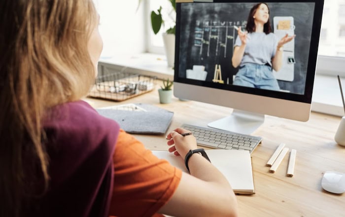 Woman watching online lecture on desktop computer