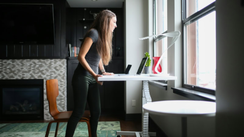 Woman working at white adjustable standing desk