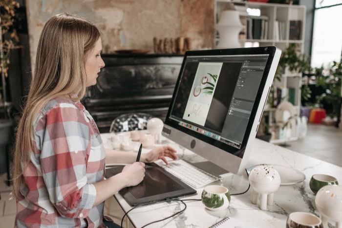 Woman working on graphic design at desktop computer