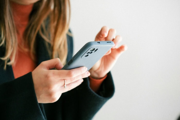 Womans hands holding and using a smartphone