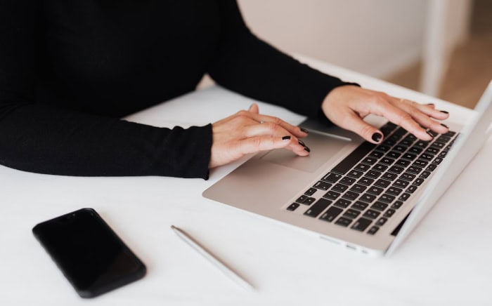 Womans hands typing on laptop keyboard