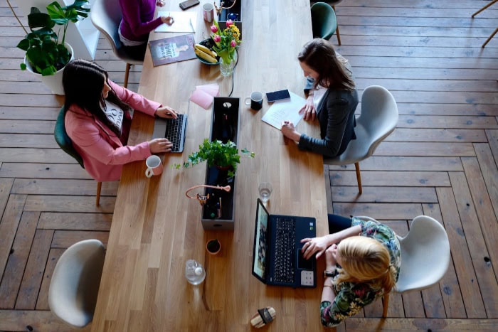 Women working with laptops and documents at a table