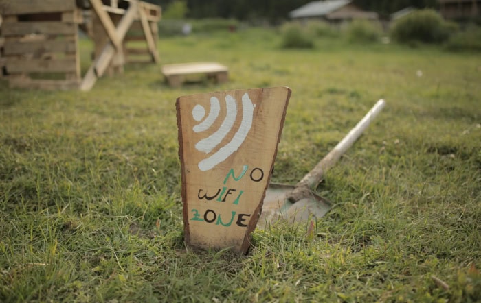 Wooden sign in grassy field indicating No WiFi Zone