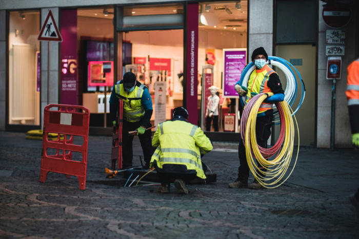 Workers installing fiber optic cables on a city street