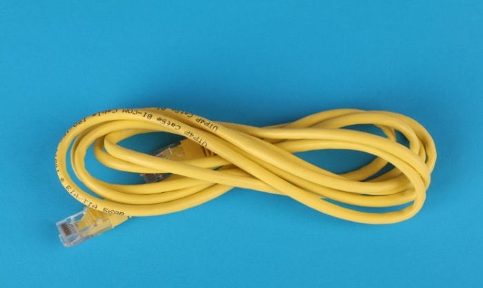Yellow ethernet cable on blue surface