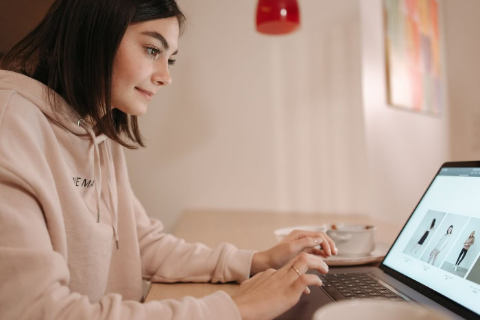 Young woman browsing online shopping website on laptop resized