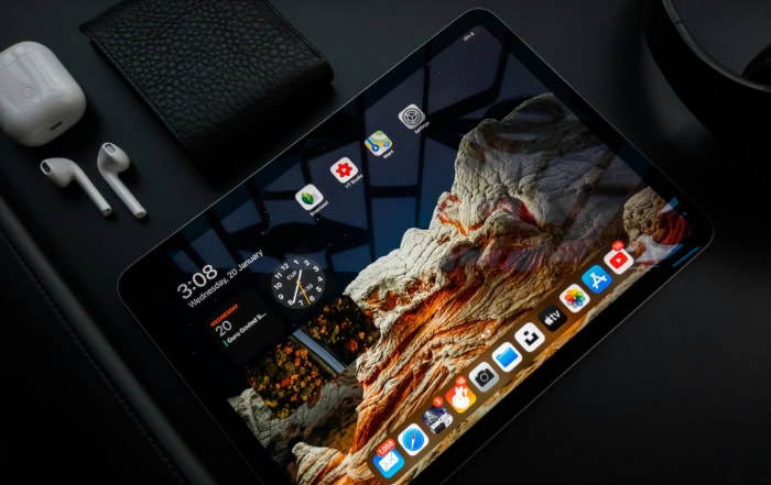 iPad displaying apps on black background with accessories
