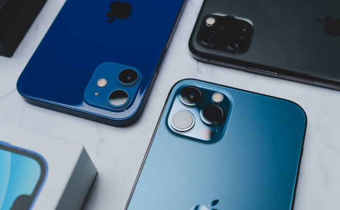 iPhone 13 models with camera lenses on white surface