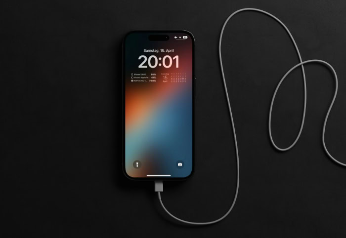 iPhone charging on black surface with lock screen