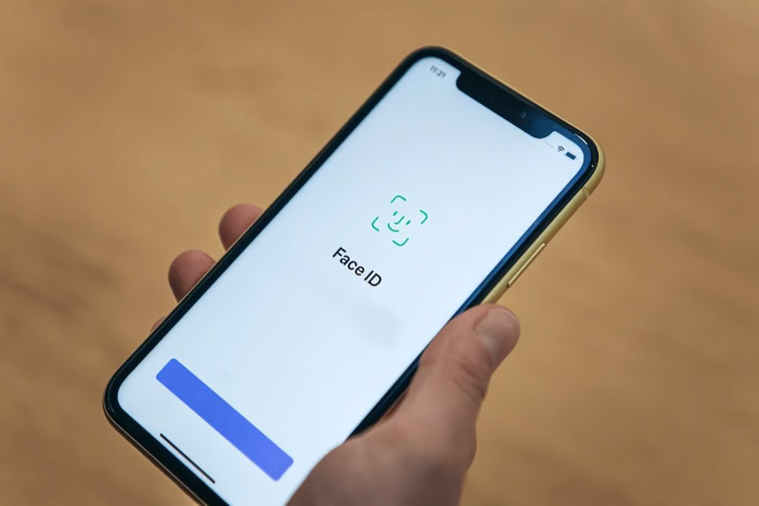 iPhone displaying Face ID setup screen with yellow case