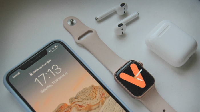 iPhone with Apple Watch AirPods and case on a table
