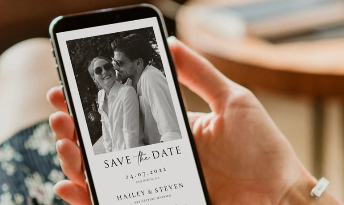 person holding save the date e card on smartphone